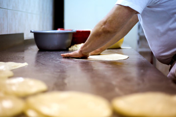 Man baker working in bakery shop