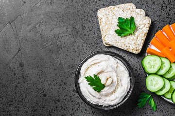 Artichoke white bean hummus on dark concrete background. Top view, space for text. 