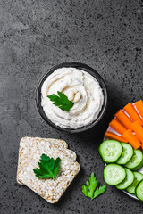 Spicy ricotta white bean dip on dark concrete background. Top view, space for text. 