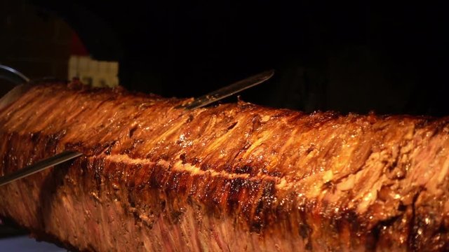 Turkish Anatolian Traditional Eastern Food Beef or Lamb Doner Kebab / Delicious Meat Food, in restaurant they cut the cooked part slicely and add it on pide and served with youghurt and tomato paste 
