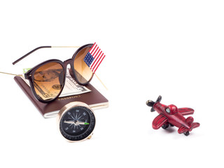 Preparation for traveling concept, black compass and plan ticket, money and sunglass on passport and red plan model on white background
