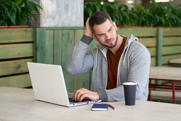 Experienced professional bearded man-the entrepreneur is considering business ideas, scratching the head