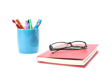 Concept Education or business : The glasses placed on red book with Colorful pens are placed in the blue mug. isolated on white background
