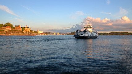 Prom na wodzie zatoki morskiej w Oslo, stolicy Norwegii, nabrzeże, budynki na brzegu, błękitne niebo © Wioletta