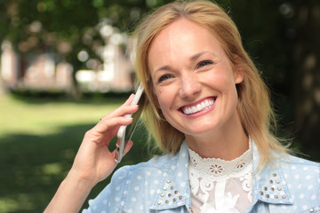 Beautiful woman in the park with a tablet or phone