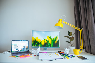 designer working place. white desk with yellow lamp