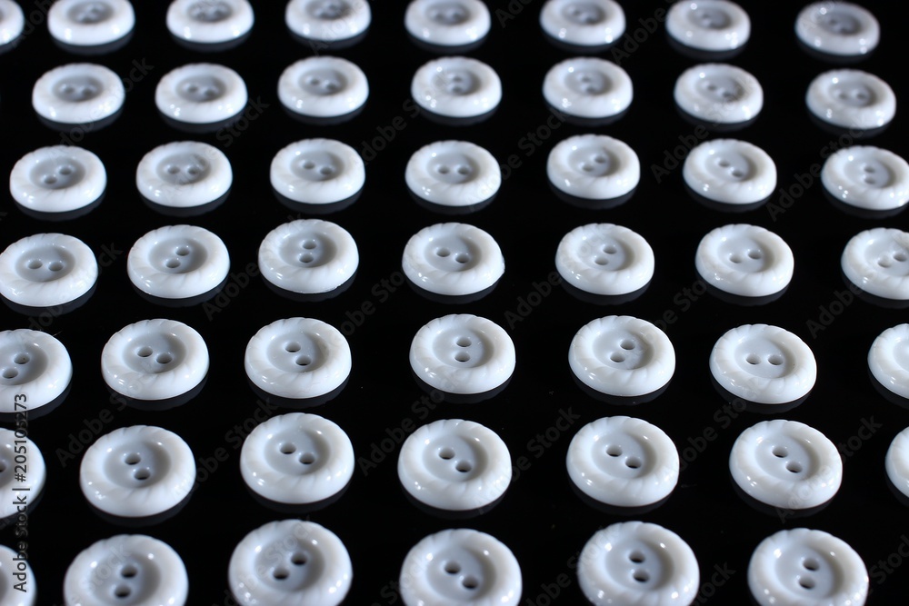 Poster white buttons on a dark background that symbolize order and structure