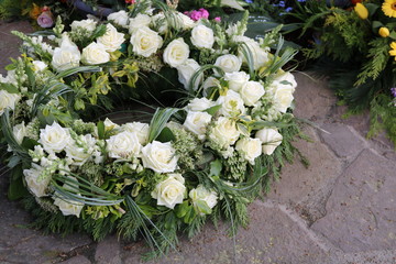 Obraz na płótnie Canvas Trauerkranz mit Blumen auf dem Friedhof 