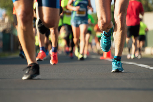 Marathon running race, people feet on city road