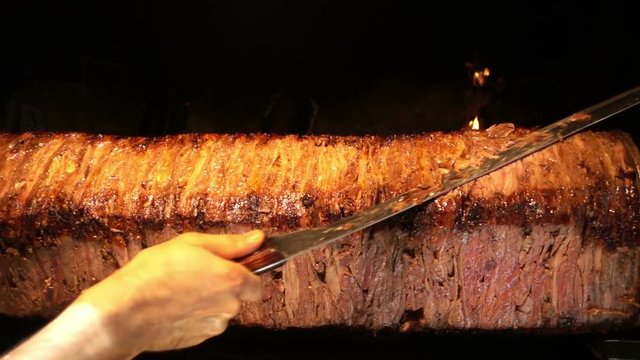 Turkish Anatolian Traditional Eastern Food Beef or Lamb Doner Kebab / Delicious Meat Food, in restaurant they cut the cooked part slicely and add it on pide and served with youghurt and tomato paste 