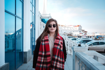 Obraz premium Cheerful female walking on city street enjoying free time on spring weekends, happy woman in sunglasses evokes sea fresh air