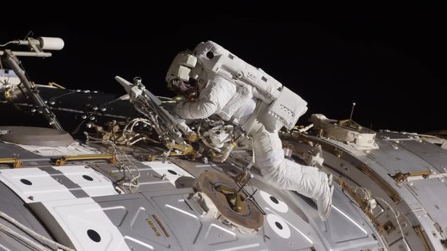Astronaut works on International Space Station, low angle