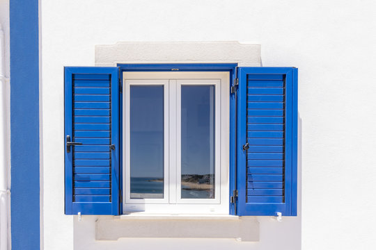 Colorida casa blanca con persianas azules en Algarve, Portugal
