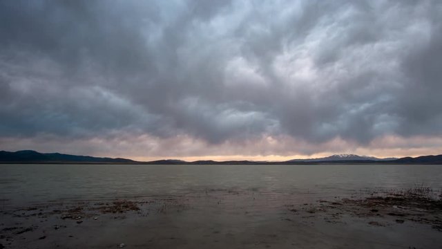 Time lapse of dramatic clouds over Utah Lake at sunset as they swirl in the sky.