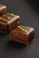 Cut chocolate praline candy on black background