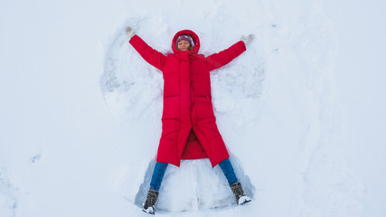 Smiling young woman doing a snow angel