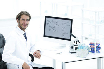 Portrait of a male scientist with a monitor looking at the camer