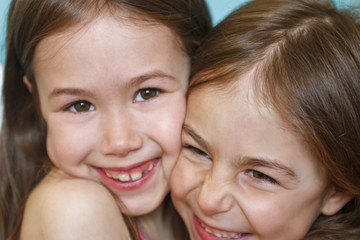 Happy little girlfriend girl smiling, looking into camera close-up