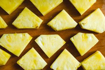 Pieces of pineapple close-up on a cutting board, top view. Fruit summer concept