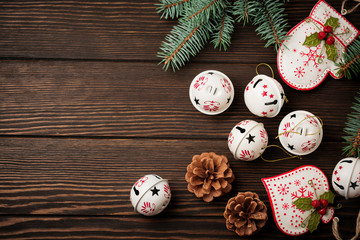 Christmas background with fir branches, toys and bells on wooden old background table. Selective focus. Top view with copy space.