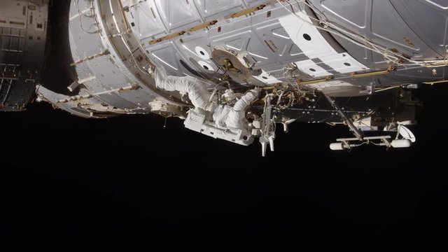 Low angle, astronaut works on International Space Station