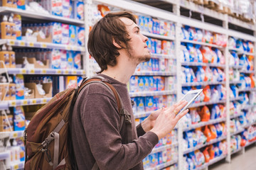 Man with a tablet chooses products in a supermarket