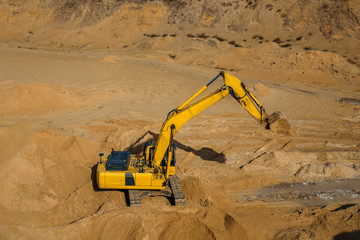 Fototapeta na wymiar Excavator loader in sand mining quarry, view from above