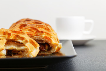 Closeup homemade strudel with apples, raisin and cinnamon on dark table. Shallow focus.