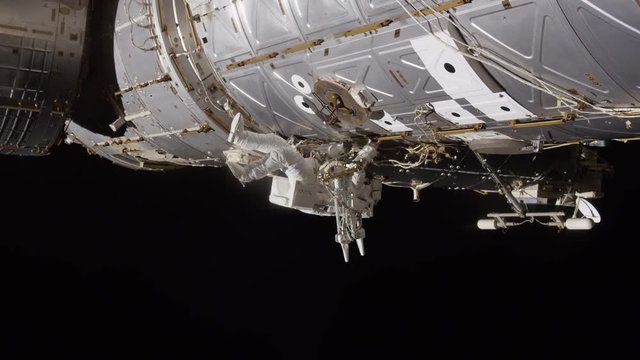 Astronaut works on International Space Station, low angle