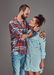 Attractive couple, bearded man and brunette girl cuddling in a studio.