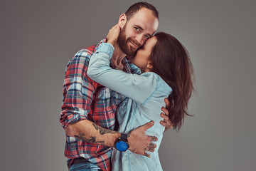 Attractive couple, bearded man and brunette girl cuddling in a studio.