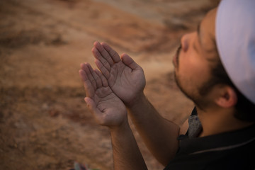 Young asian muslim man praying on sunset,Ramadan festival concept,Thailand people,Blessings from the Allah,