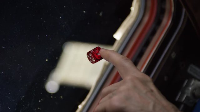 Astronaut plays with die in anti gravity, close up