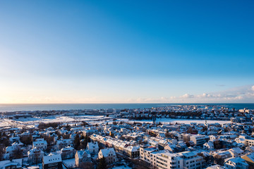 Reykjavik downtown in a golden evening light. Capital city of Iceland Reykjavik in winter surrounded with snow covered mountains.