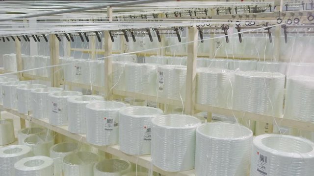 synthetic threads move from bobbins to loom close view
