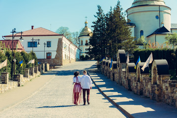 Obraz premium A beautiful young couple goes to the church in embroidery during the wedding