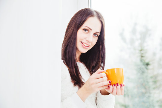 Pretty brunette woman with orange coffee cup
