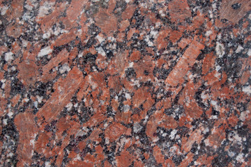 Reddish-brown granite texture with black and gray spots. Used as a background.