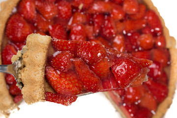 Stück Erdbeerkuchen, Kuchen mit Erdbeeren im Hintergrund