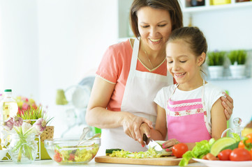 mother and daughter preparing breakfast