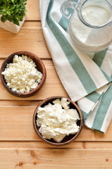 Top view, close up homemade cottage cheese in a bowl on old wooden table.