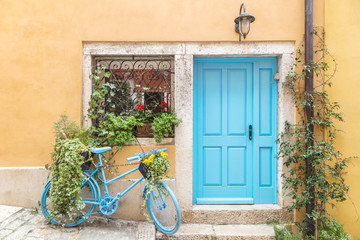 Fototapeta na wymiar Still life with blue bicycle at door and window of a house in Rovinj, Croatia, Europe.