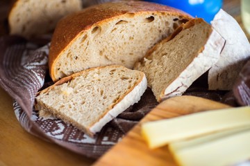 Sliced bread and cheese on wooden kitchen board.