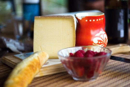 Cheese, bread, raspberry and red jug.