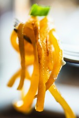 Pumpkin noodle hanging on fork.