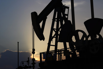 Siluette of oil pump station in sunset. Tansport and distribution of oil. Technology of oil...