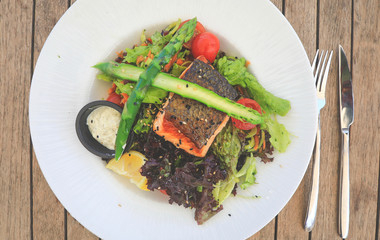 Grilled salmon steak and vegetarian vegetable salad of tomatoes, asparagus, lettuce salad. Healthy proper nutrition. Top view.