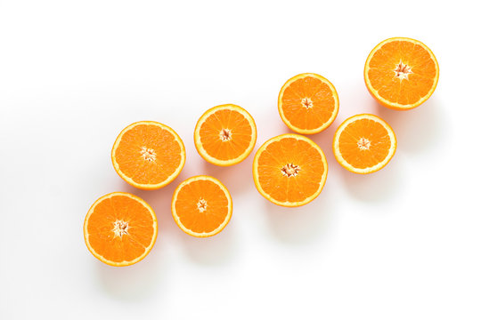 Juicy, fresh oranges, cut into pieces on a white background.