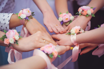 Fototapeta premium bridesmaids with wedding bouquet of flowers at wedding ceremony. girlfriends with a petting boutonniere on the wedding day. friends with wedding flowers. woman with flowers of wedding hands champagne