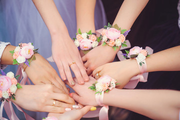 Obraz na płótnie Canvas bridesmaids with wedding bouquet of flowers at wedding ceremony. girlfriends with a petting boutonniere on the wedding day. friends with wedding flowers. woman with flowers of wedding hands champagne
